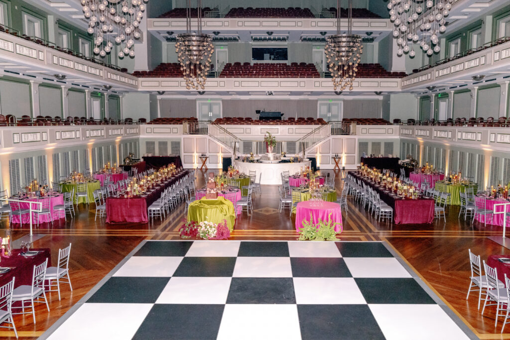 Nashville Symphony wedding reception with chartreuse, burgundy, and fuchsia tables, candlelight, and checkered dance floor designed by Nashville wedding planners