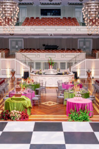 Nashville Symphony wedding reception with chartreuse and fuchsia tables, central bar, and candlelit tablescape design